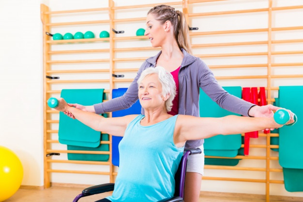Senior woman in wheel chair doing physical therapy